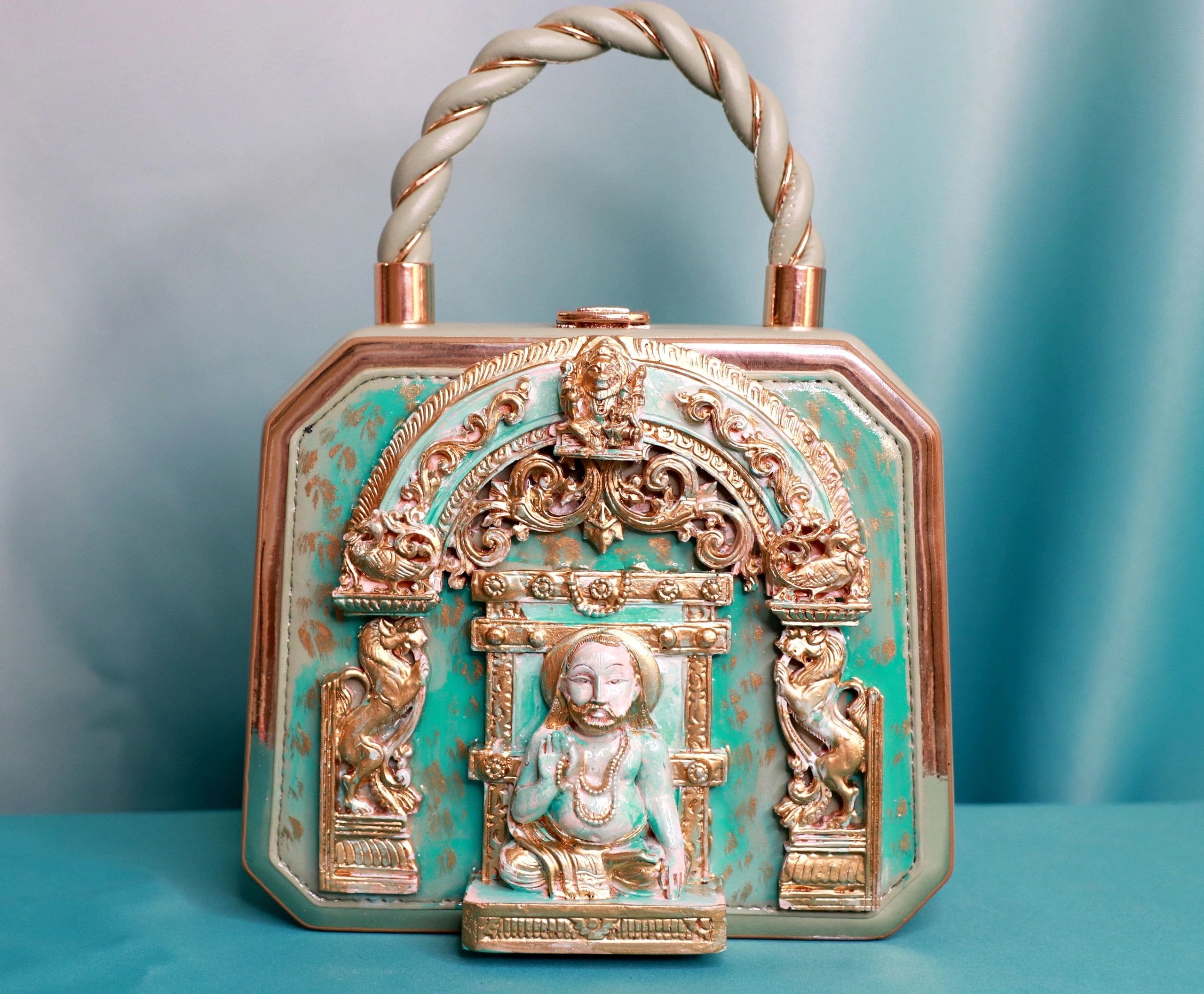 A purse with a statue of a person in it.