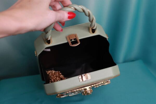 A woman is holding onto the handle of her purse.