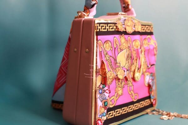 A pink suitcase with some figurines on top of it
