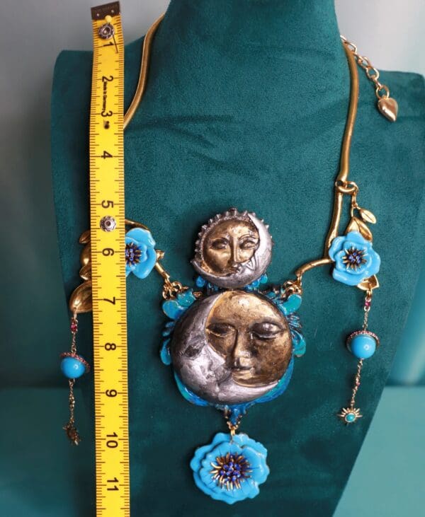 A necklace with blue flowers and a face on it