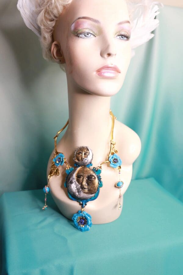 A mannequin wearing a necklace and earrings.