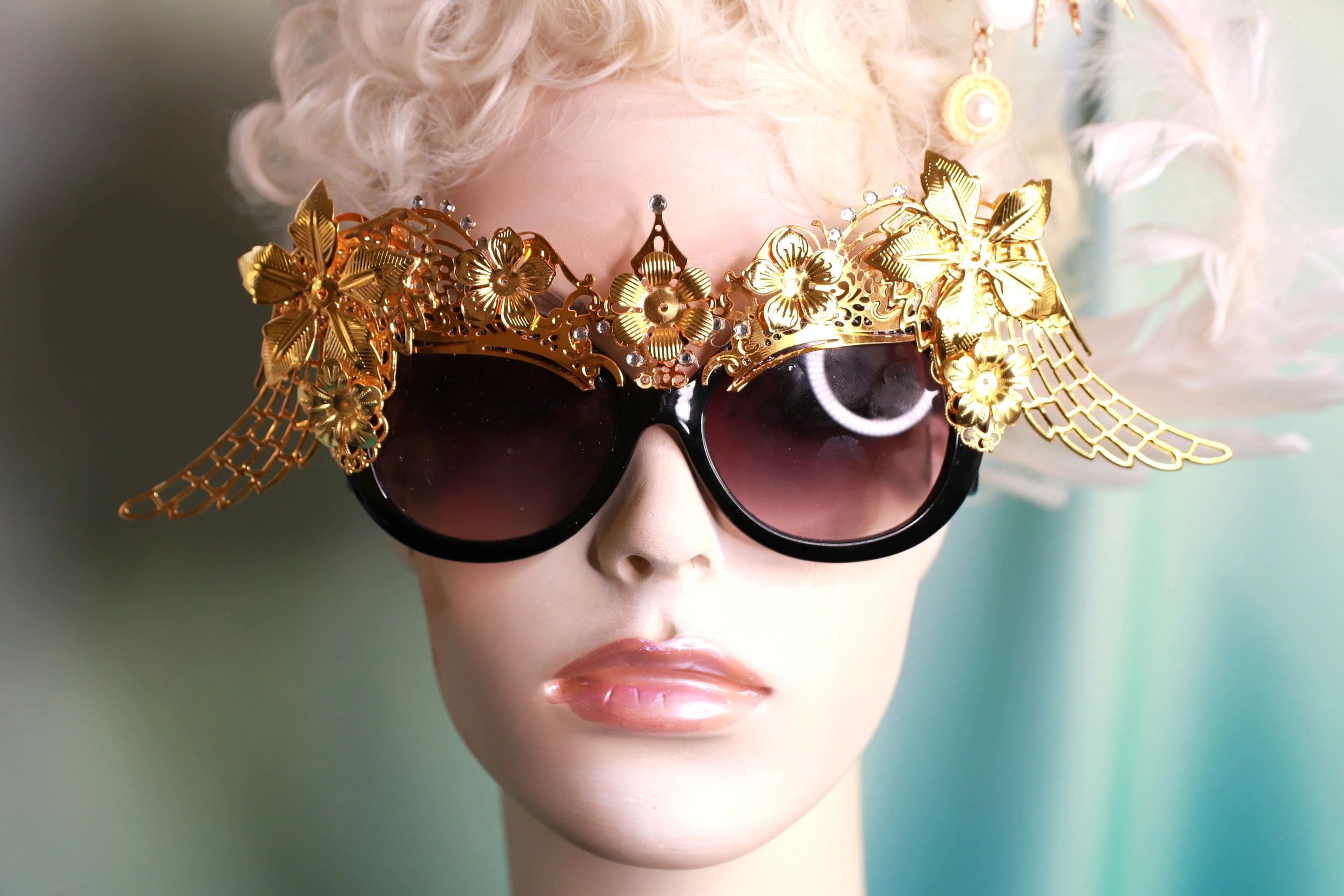 A woman wearing sunglasses with gold flowers on it.