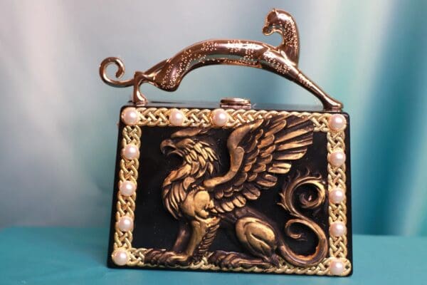 A purse with a picture of a griffin on it.