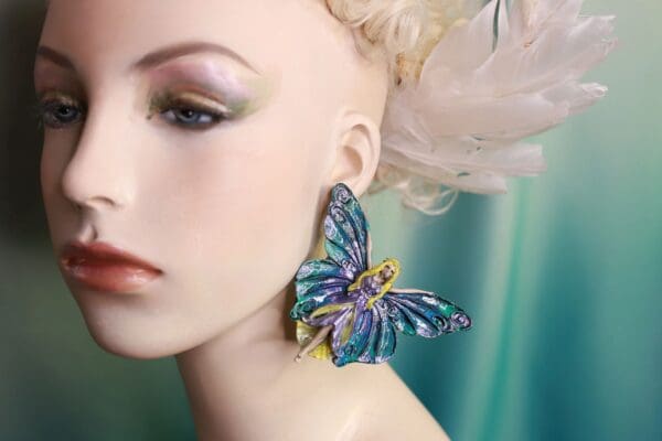 A woman wearing blue and yellow butterfly earrings.