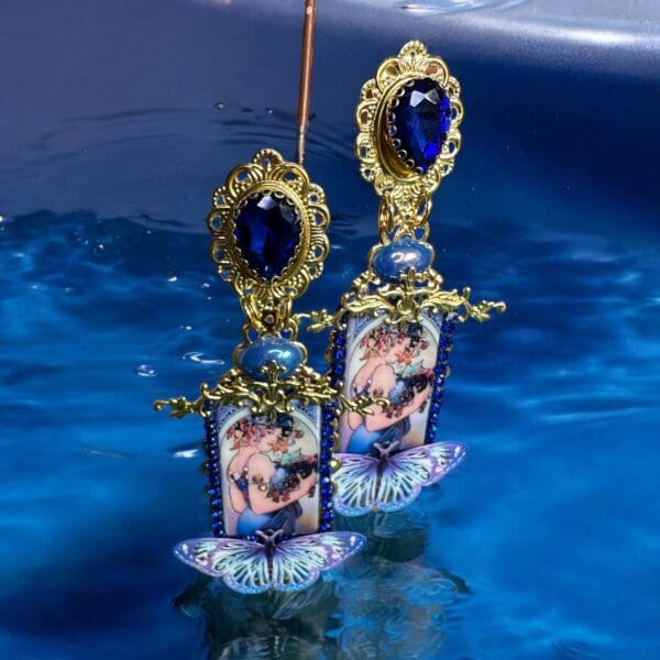 A pair of earrings sitting on top of water.