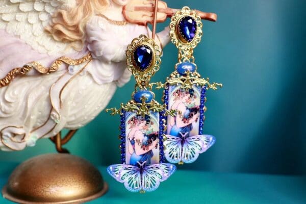 A pair of earrings with blue stones and gold chains.