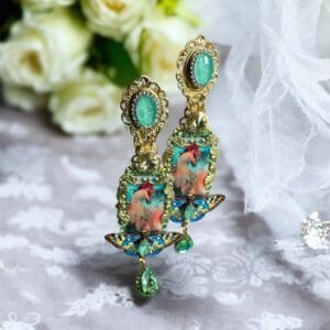 A pair of earrings with green stones and flowers.