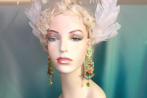 A mannequin wearing earrings and feathers.