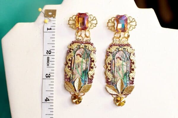 A pair of earrings with a woman on it