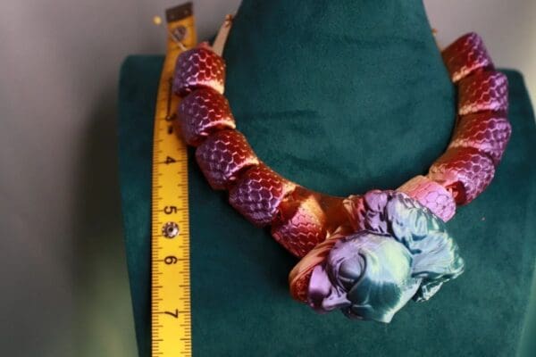 A green chair with a red snake necklace and a ruler