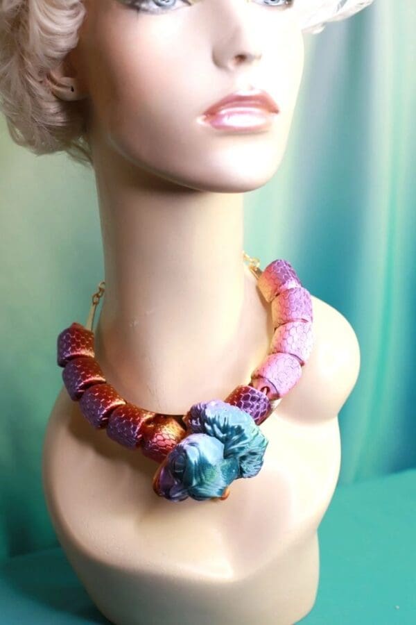A woman wearing a necklace with beads and a stone.