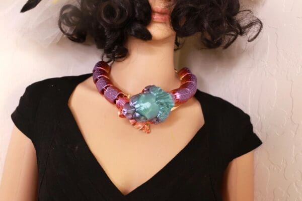 A woman wearing a necklace with a crab on it.