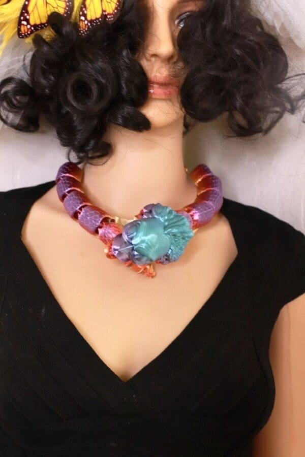 A woman wearing a necklace with purple beads and blue stone.