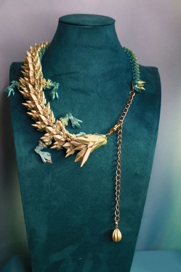 A green velvet necklace with gold leaves and chains.