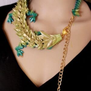 A woman wearing a necklace with leaves on it.