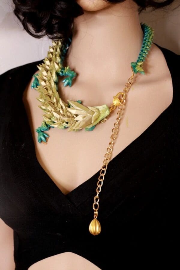 A woman wearing a necklace with green and gold lizard design.