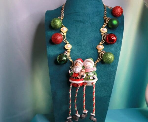A necklace with two santa clause on it