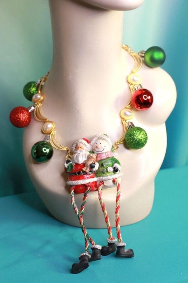A white necklace with christmas ornaments and red, green and white beads.
