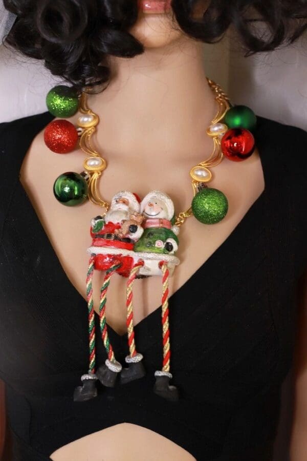 A woman wearing a necklace with christmas decorations.