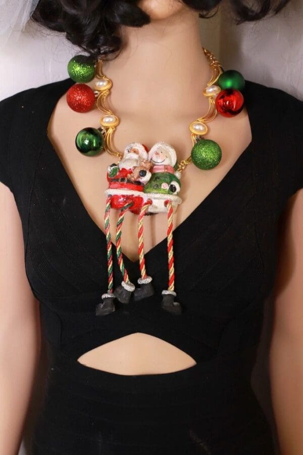 A woman wearing a necklace with christmas ornaments.