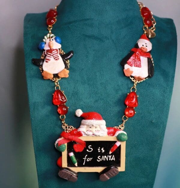 A necklace with santa and penguins on it.