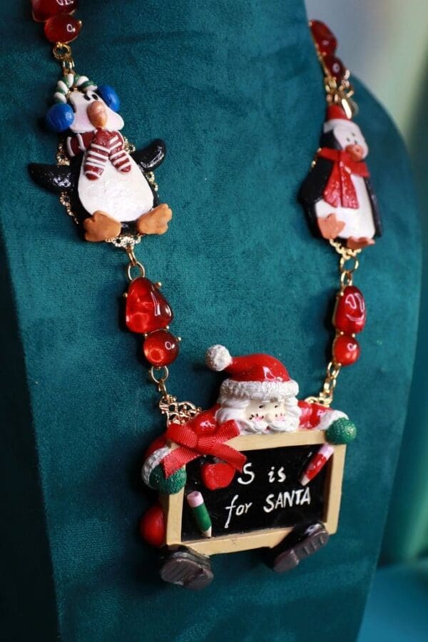 A necklace with santa and penguins on it.