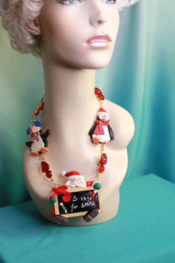 A bust of a woman wearing a necklace with santa and penguins.