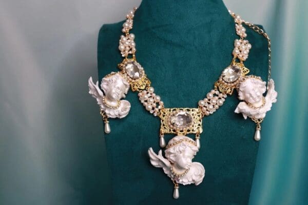 A necklace with angels and pearls on it
