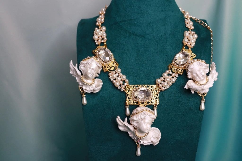 A necklace with angels and pearls on it