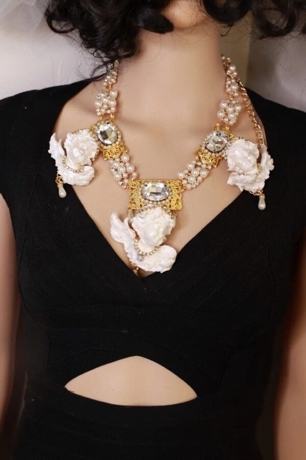 A woman wearing a necklace with white flowers.