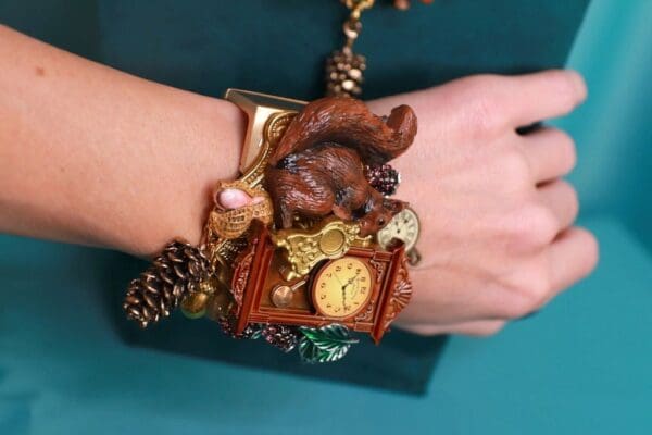 A woman 's wrist with a bracelet and clock on it.