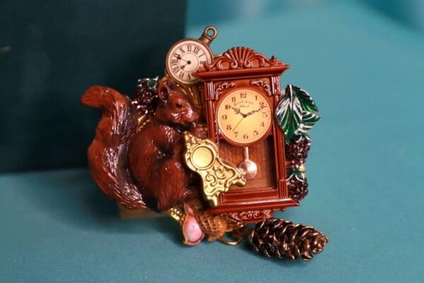 A clock with a squirrel and pine cones on it