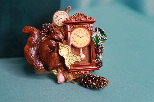 A clock and squirrel figurine on top of a table.