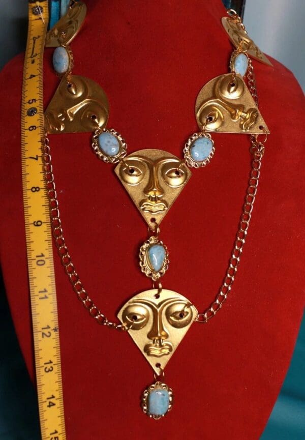 A necklace with faces on it and a ruler