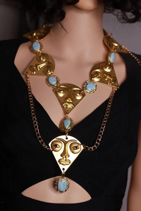 A woman wearing a necklace with faces on it.