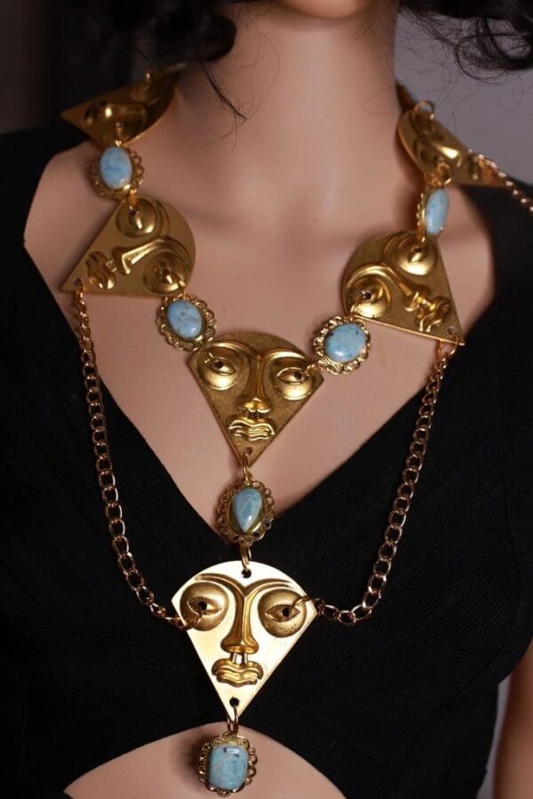 A woman wearing a necklace with faces on it.