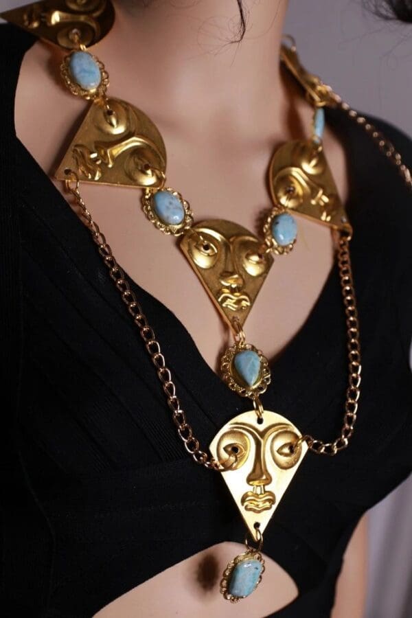 A woman wearing a necklace with faces on it.