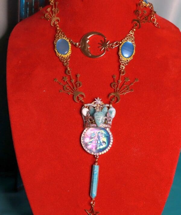 A red velvet display with a necklace and elephant pendant.