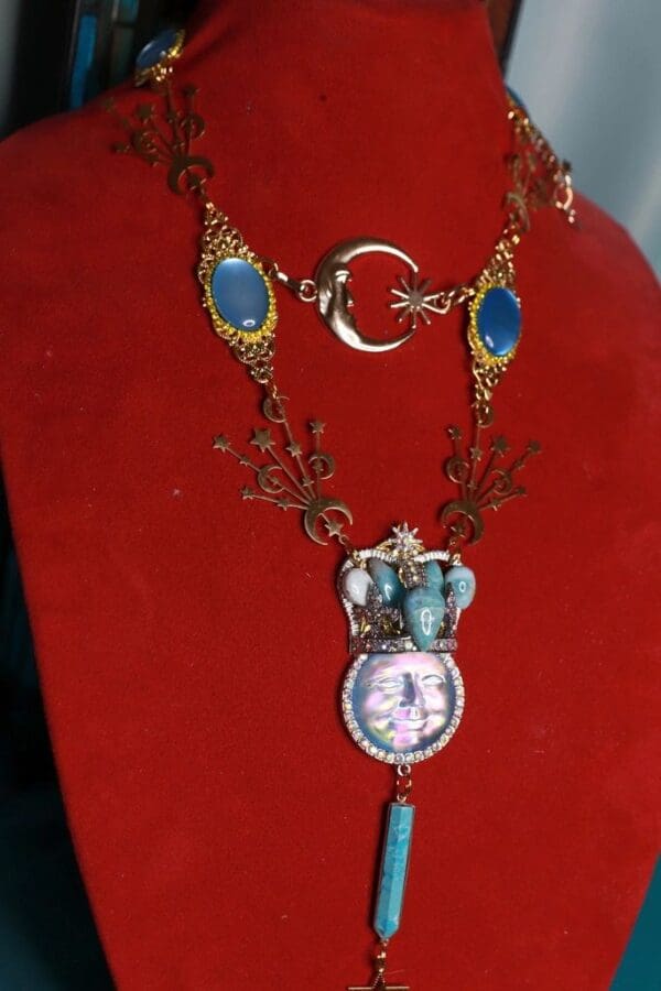 A red velvet display with a necklace and clock.