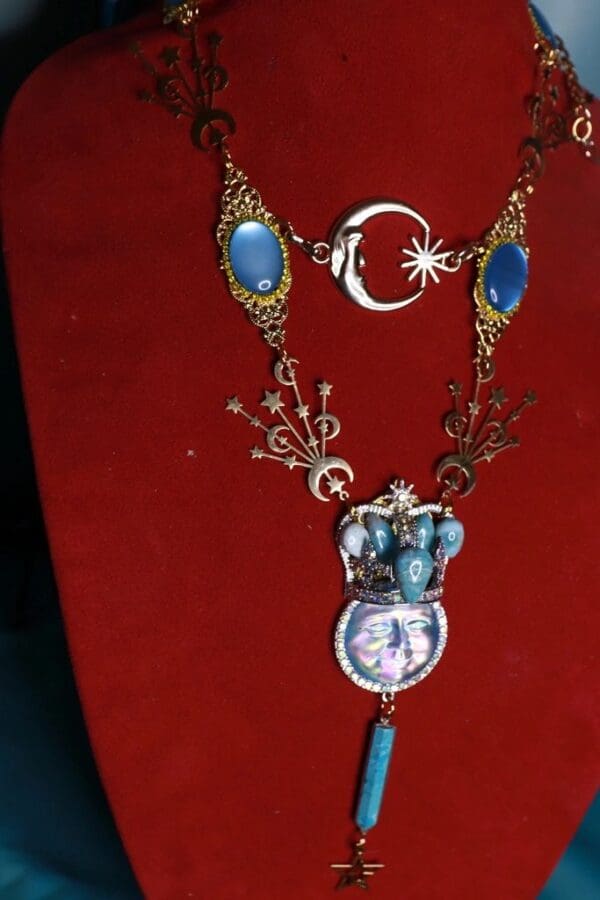 A necklace with blue stones and a moon on it.