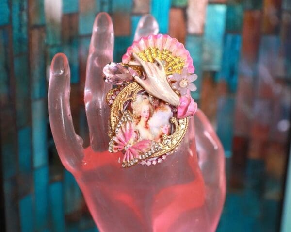 A hand with a pink and white shell on it