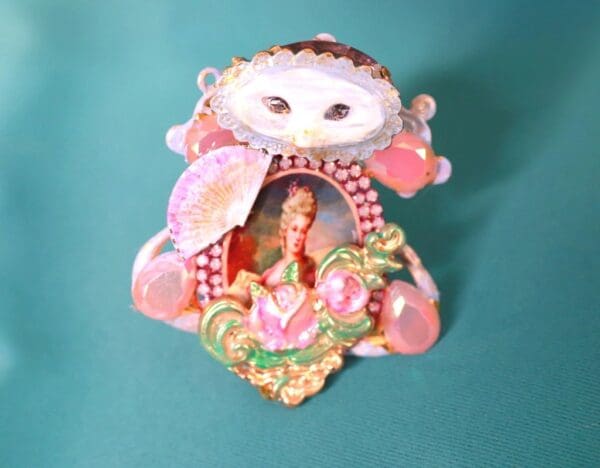 A pink and white cat figurine sitting on top of a table.