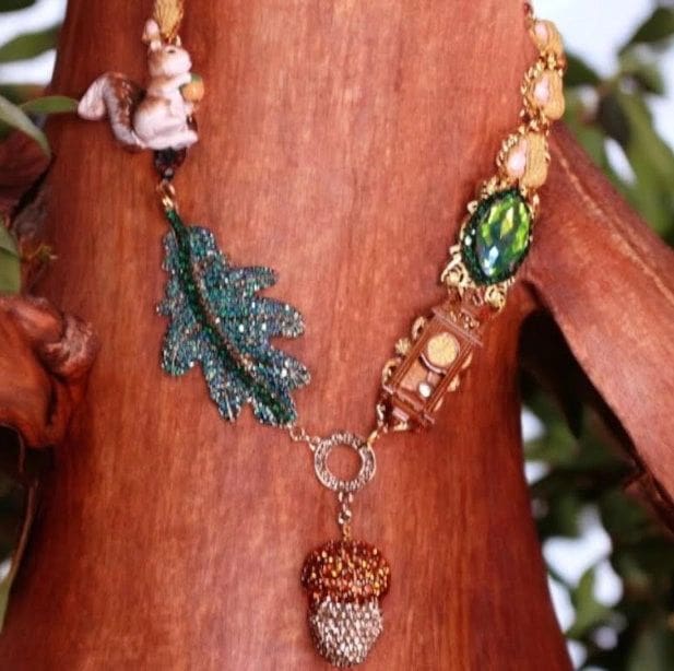 A wooden tree with a necklace of beads and leaves.