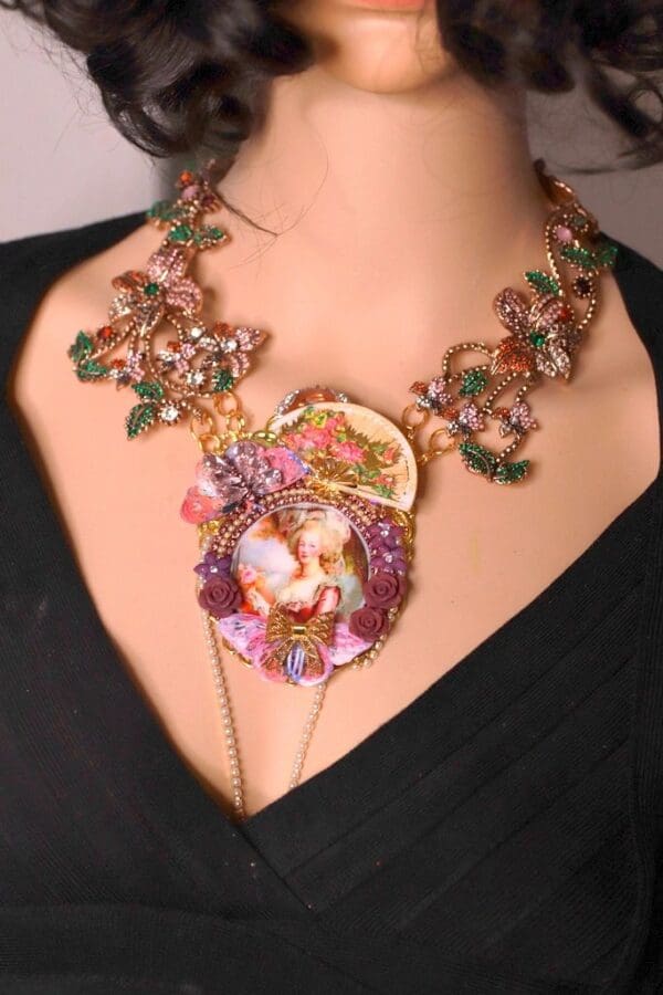 A woman wearing a necklace with flowers and leaves.
