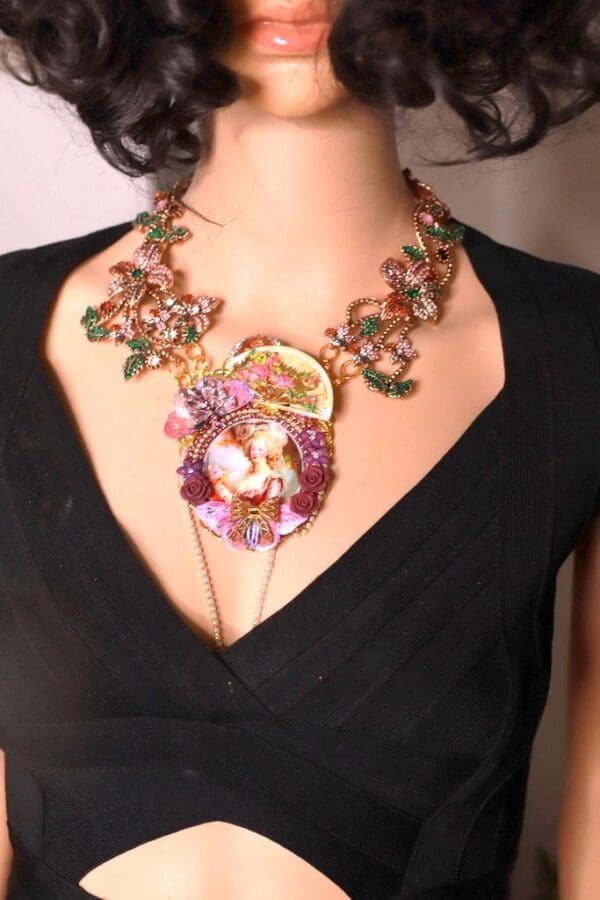A woman wearing a necklace with flowers and a face.