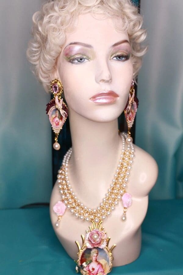 A mannequin wearing jewelry and earrings in front of a blue background.