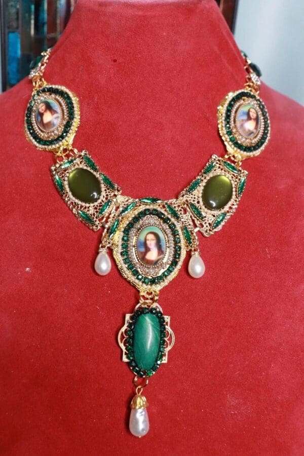 A necklace with green and gold accents on a red background