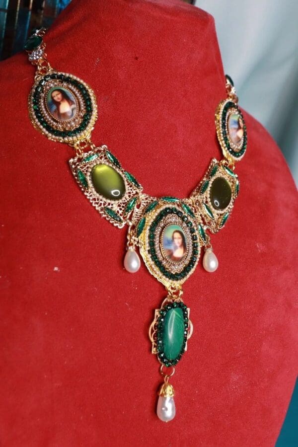 A necklace with green stones and pearls on red velvet.