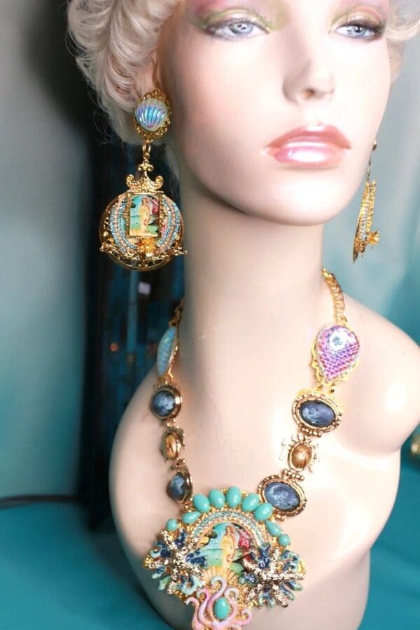 A woman wearing a necklace and earrings with a bird on it.
