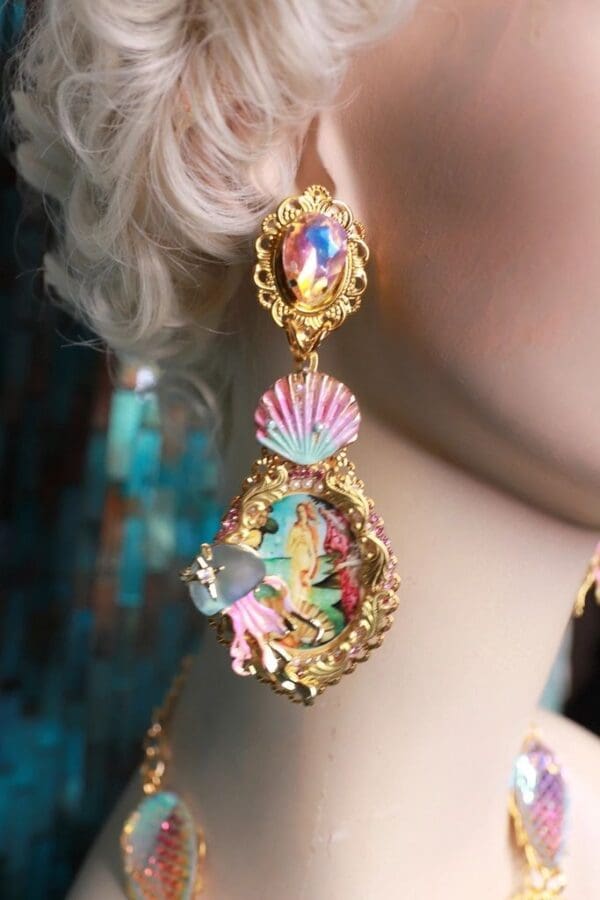 A woman wearing colorful earrings with gold frame.